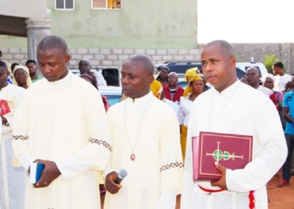 fonte: https://www.consolersofchrist.com/   Reverendo Barnabé Nyowe à direita segurando o livro.
